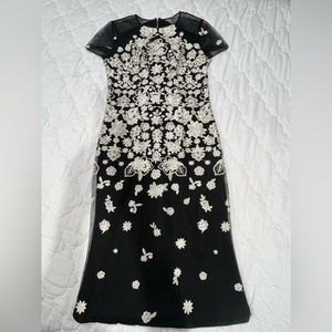 The brand is Carmen Marc Valvo. It is a 4, and the colors are black and silver.